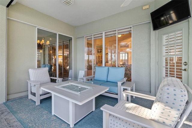 view of patio with an outdoor living space with a fire pit