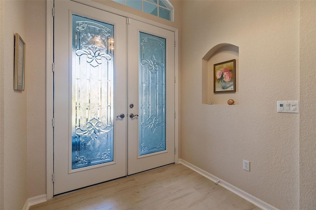 foyer featuring french doors and light hardwood / wood-style flooring