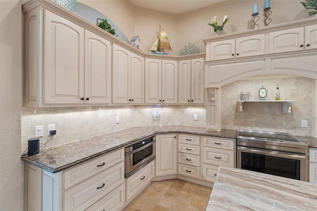 kitchen featuring decorative backsplash, cream cabinets, stainless steel range with electric cooktop, and light stone counters