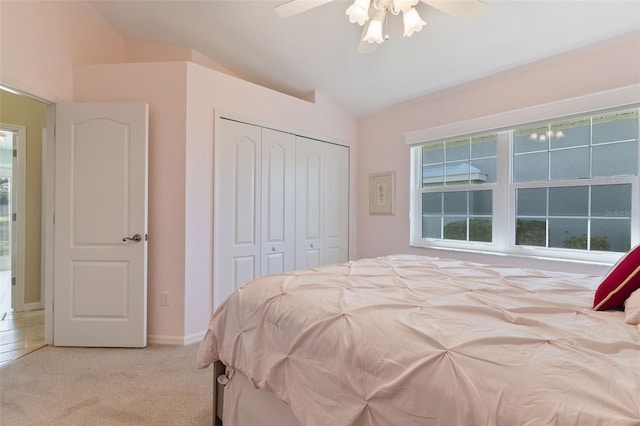 carpeted bedroom with a closet, ceiling fan, and lofted ceiling