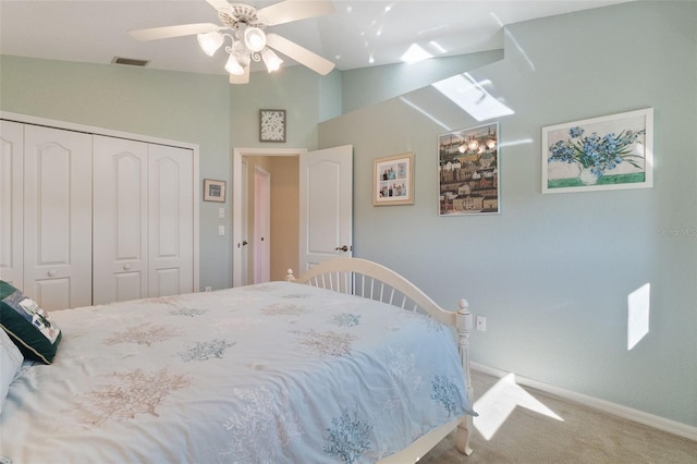 carpeted bedroom with a closet, vaulted ceiling, and ceiling fan