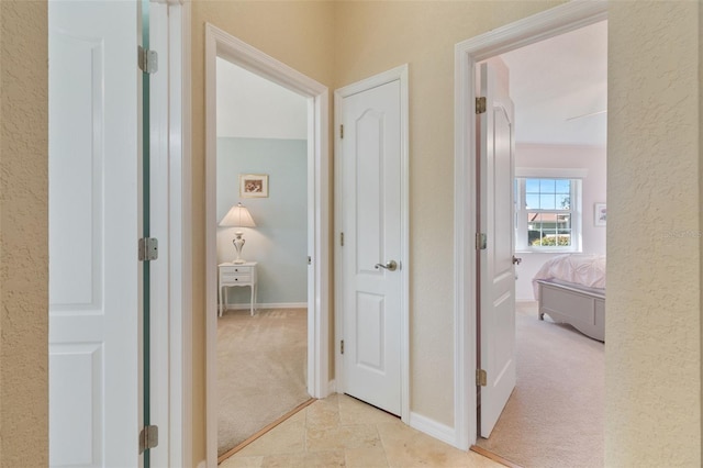 hall featuring light colored carpet