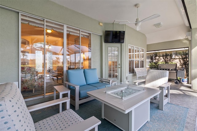 view of patio / terrace featuring area for grilling, ceiling fan, and an outdoor living space with a fire pit