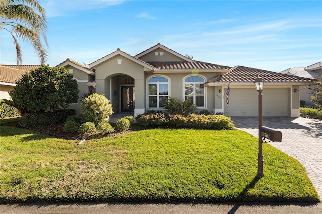 mediterranean / spanish house featuring a front yard and a garage