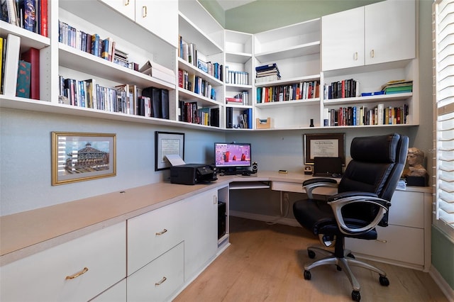 home office with built in desk and light wood-type flooring