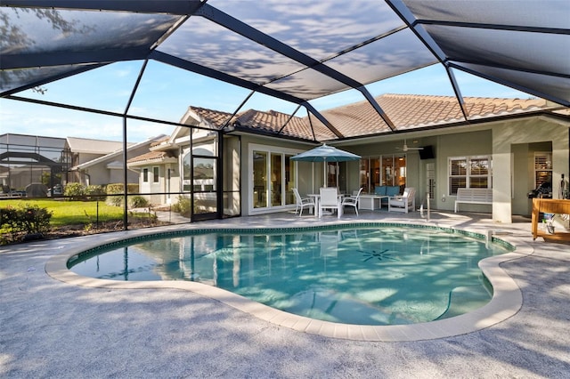 view of pool with a patio, ceiling fan, and glass enclosure