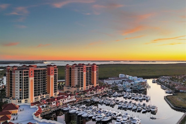 aerial view at dusk featuring a water view