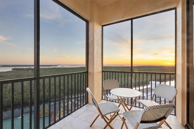 sunroom / solarium featuring a water view