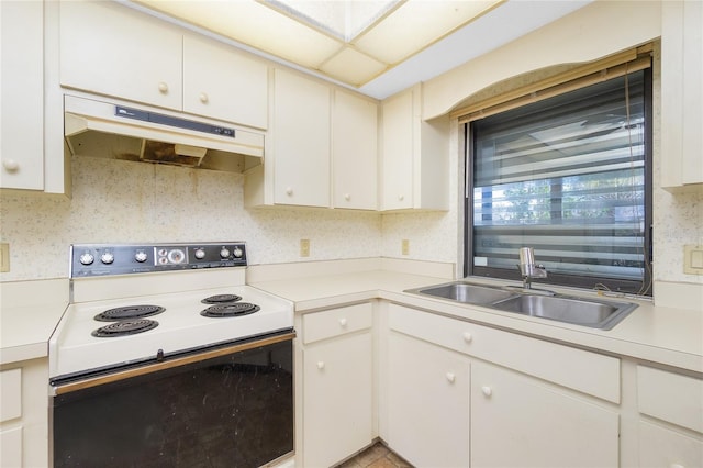 kitchen with white cabinets, sink, decorative backsplash, and range with electric stovetop