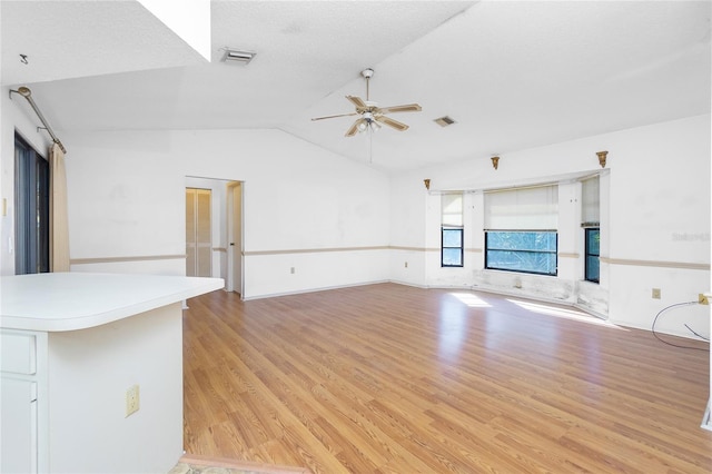 unfurnished living room featuring ceiling fan, lofted ceiling, and light wood-type flooring