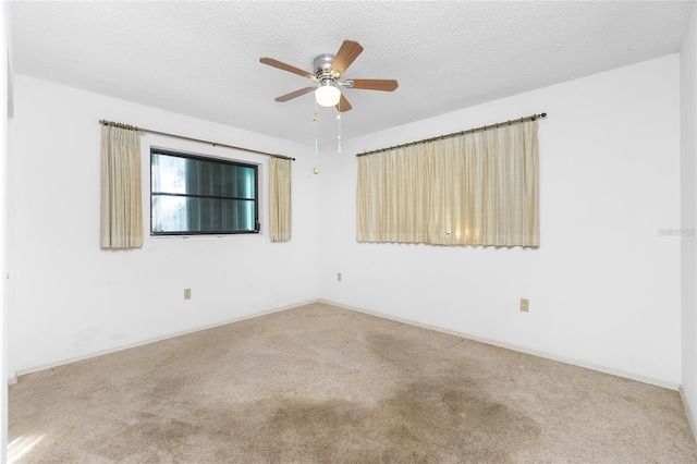 empty room with ceiling fan, carpet floors, and a textured ceiling