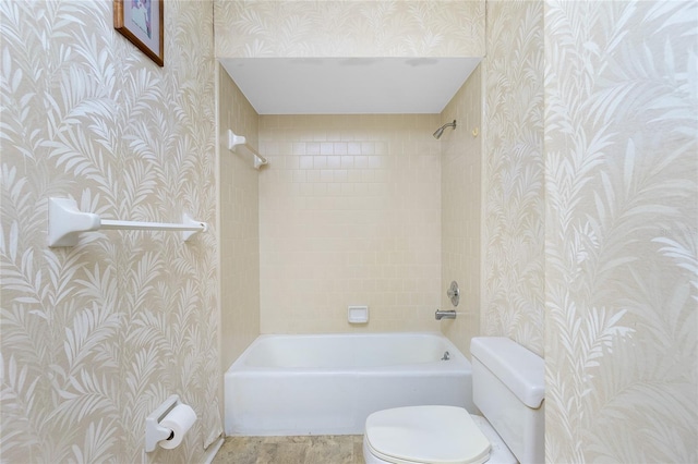 bathroom with tiled shower / bath combo and toilet