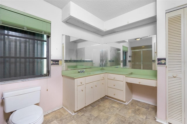 bathroom with vanity, an enclosed shower, a textured ceiling, and toilet