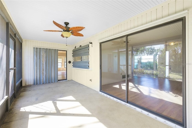 unfurnished sunroom featuring ceiling fan