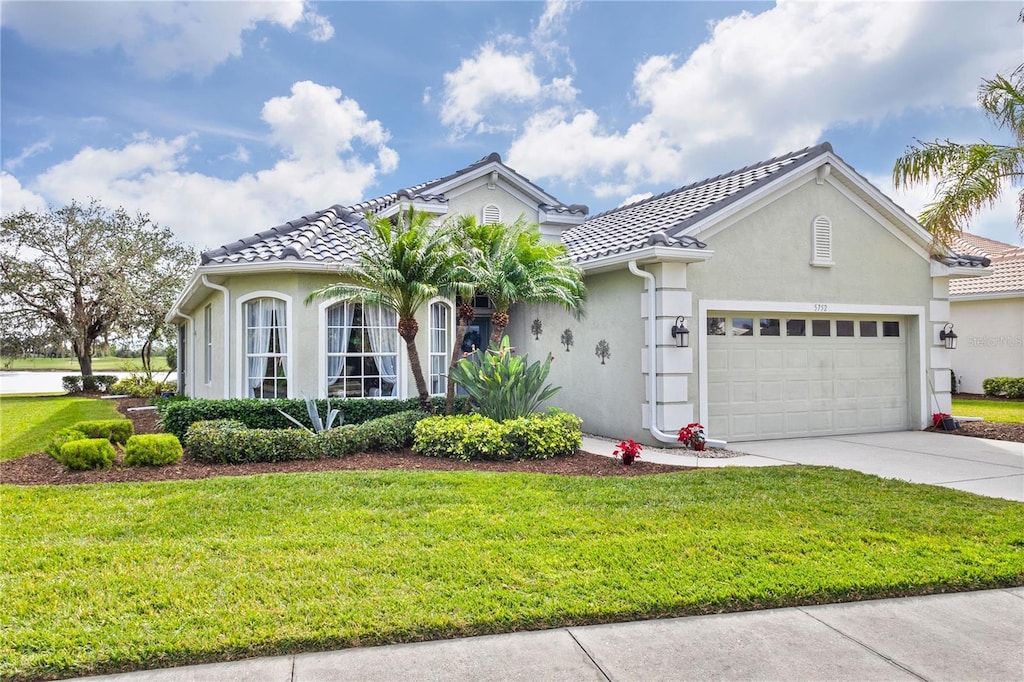 view of front of home with a garage and a front lawn