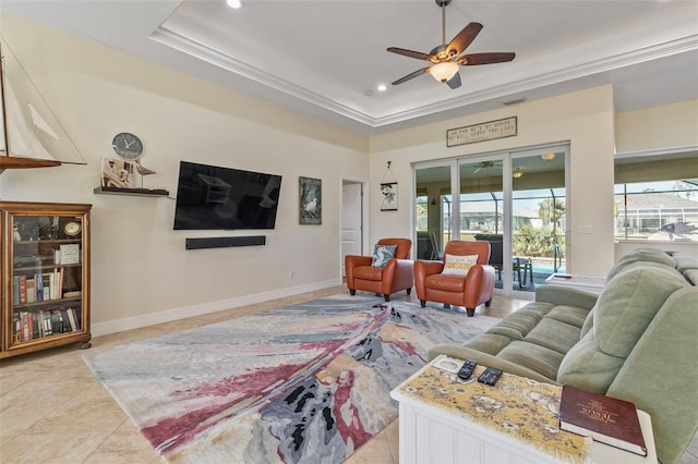 tiled living room featuring ceiling fan, ornamental molding, and a tray ceiling