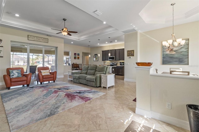 living room featuring ceiling fan with notable chandelier, a raised ceiling, and light tile patterned floors