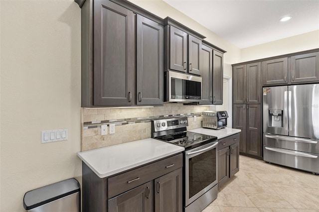 kitchen with dark brown cabinets, stainless steel appliances, and tasteful backsplash