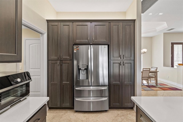 kitchen with a raised ceiling, dark brown cabinetry, stainless steel refrigerator with ice dispenser, and ornamental molding