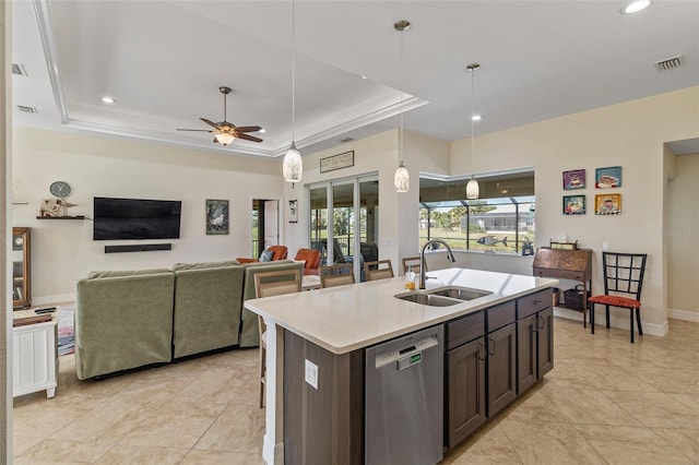 kitchen with dishwasher, a raised ceiling, a kitchen island with sink, and sink