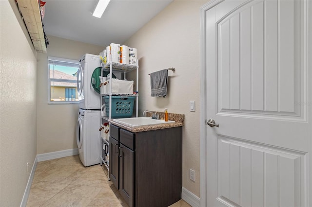 washroom with cabinets, sink, light tile patterned floors, and stacked washing maching and dryer