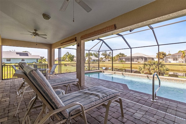 view of pool with pool water feature, glass enclosure, and ceiling fan