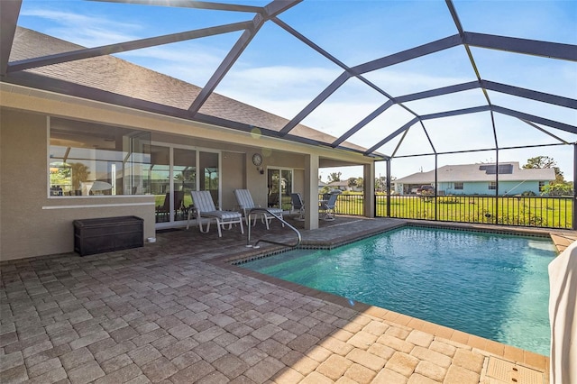 view of swimming pool featuring a lanai, a patio area, and a lawn