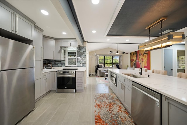 kitchen with tasteful backsplash, gray cabinetry, stainless steel appliances, vaulted ceiling, and sink