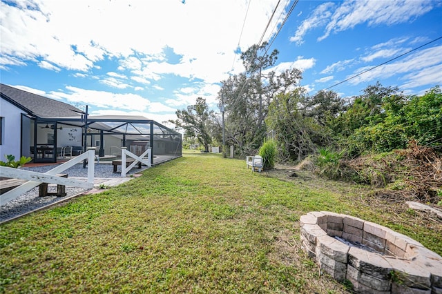 view of yard with glass enclosure and a fire pit