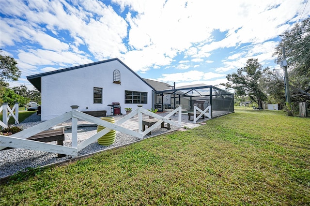 back of house with a lawn and glass enclosure