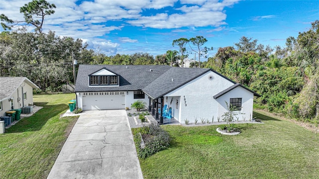 view of front of property with central AC, a front yard, and a garage