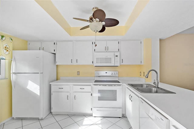 kitchen featuring white cabinetry, a raised ceiling, white appliances, and sink