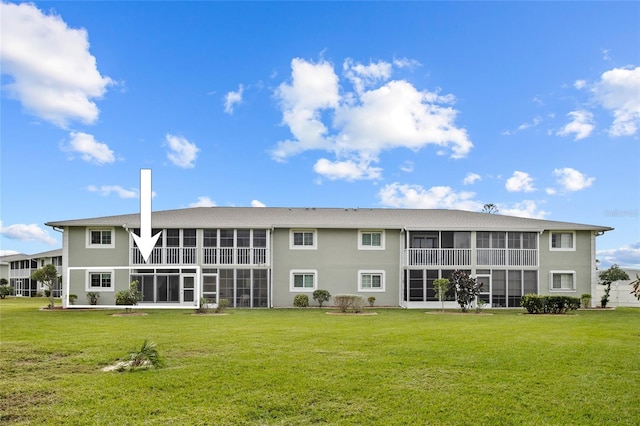 back of property featuring a sunroom and a yard