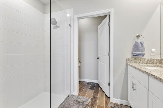 bathroom with a tile shower and vanity