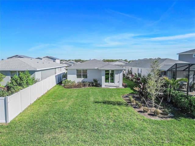 back of house with a lanai and a yard