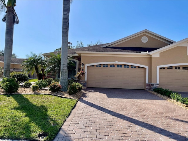 ranch-style home with a garage and a front lawn