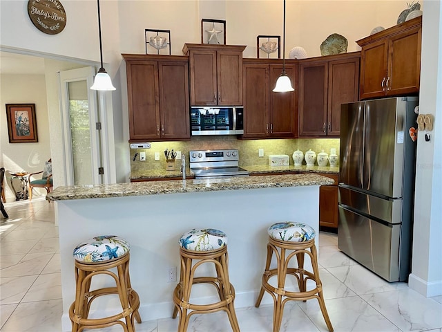 kitchen featuring tasteful backsplash, light stone countertops, decorative light fixtures, and appliances with stainless steel finishes