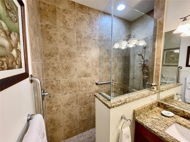 bathroom with a tile shower and vanity