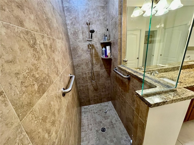 bathroom with a tile shower and sink