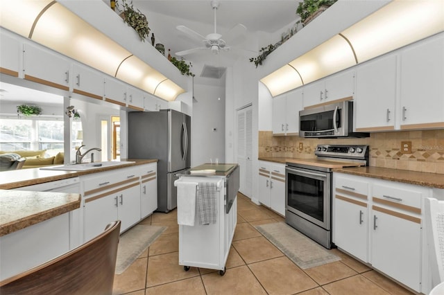 kitchen featuring sink, ceiling fan, appliances with stainless steel finishes, tasteful backsplash, and white cabinetry