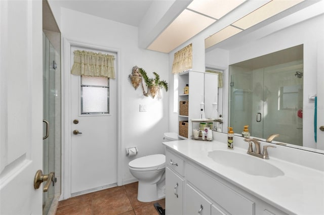 bathroom with tile patterned flooring, vanity, toilet, and walk in shower