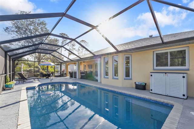 view of swimming pool with glass enclosure and a patio