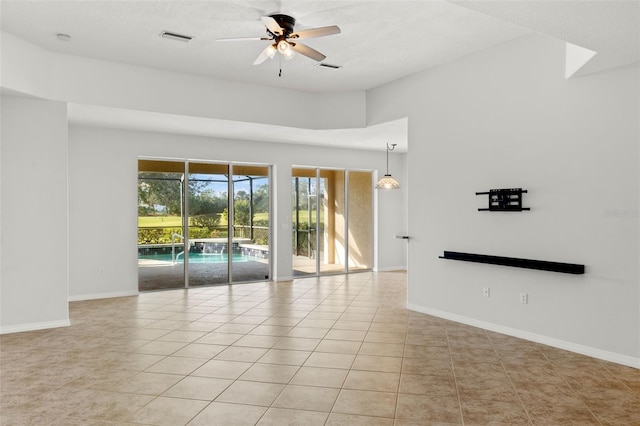 tiled spare room featuring a high ceiling and ceiling fan