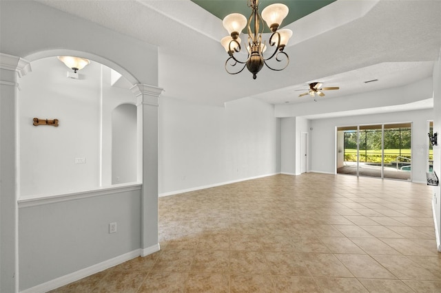 tiled spare room with a textured ceiling, ornate columns, and ceiling fan with notable chandelier