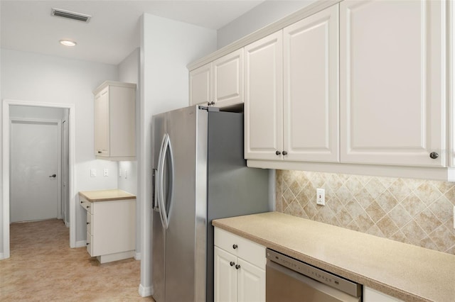 kitchen featuring white cabinets, decorative backsplash, and stainless steel appliances