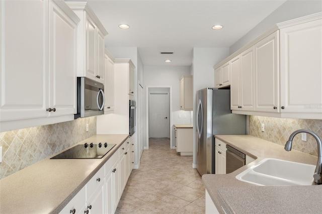 kitchen with backsplash, white cabinetry, sink, and appliances with stainless steel finishes