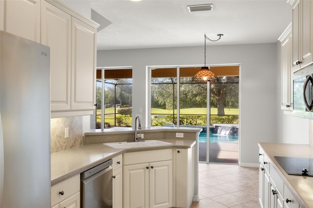 kitchen featuring stainless steel appliances, sink, pendant lighting, white cabinets, and light tile patterned flooring