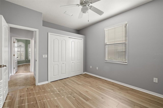 unfurnished bedroom with ceiling fan, light hardwood / wood-style floors, and a closet