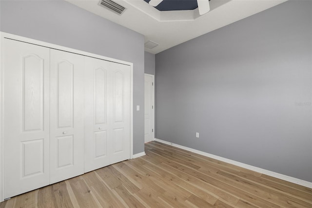 unfurnished bedroom with ceiling fan, light hardwood / wood-style floors, and a closet