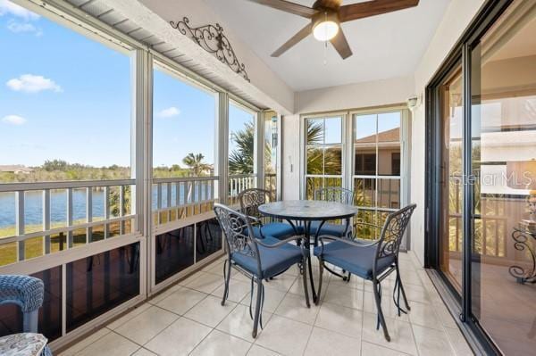 sunroom featuring a water view and ceiling fan